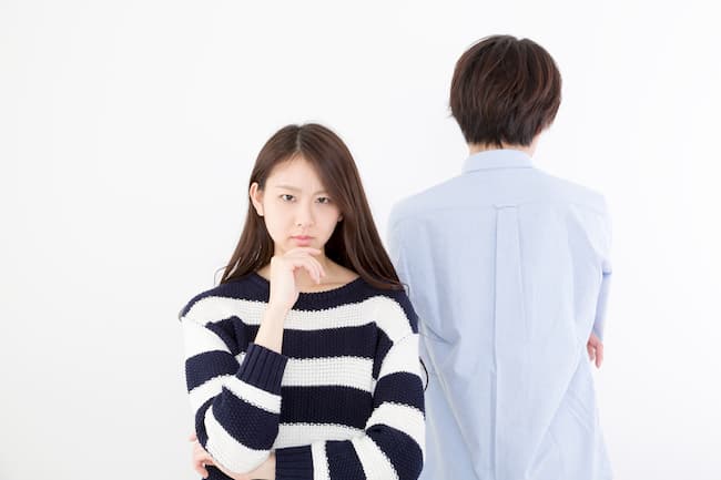 ボーダー柄の服を着て怪しむ女性