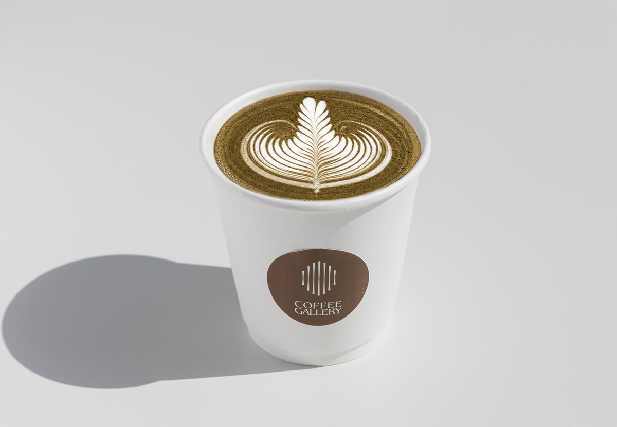 COFFEE GALLERYの炭ラテ。ラテアートが描かれたテイクアウトカップ