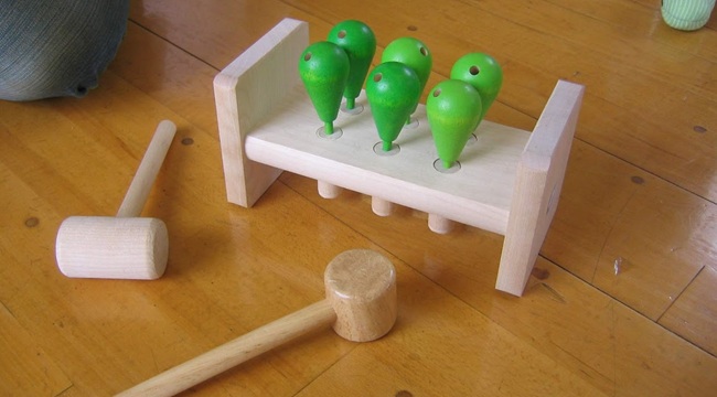 ハンマートイのペグの穴に他のおもちゃを差し込んで遊ぶ1歳の男の子